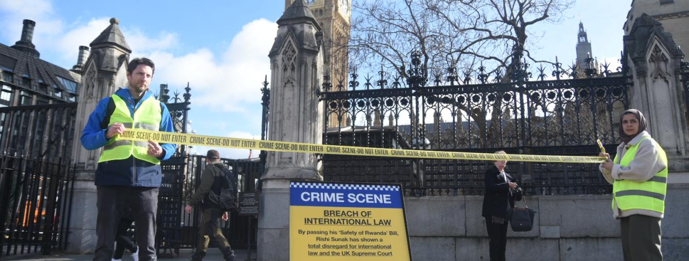 Two peope in Hi-Vis hold 'Crime scene' tape in front of a 'Crime scene' sign outside Parliament